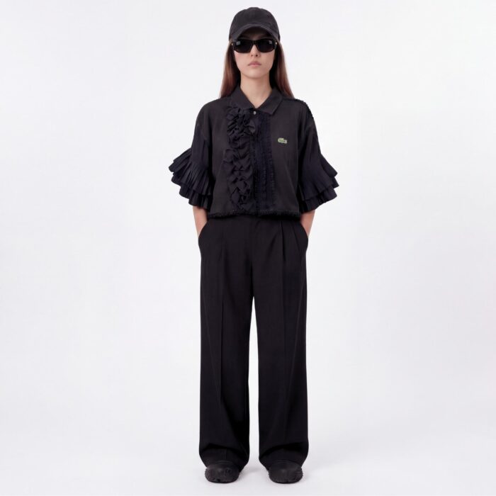 Polo Lacoste vintage col jabot destructuré sur un seul côté porté par une mannequin brune vue de plein pied de face